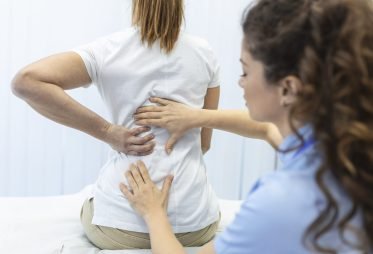 Physiotherapist doing healing treatment on womans back. Back pain patient, treatment, medical doctor, massage therapist.office syndrome
